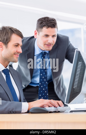 Businessmen using computer at office desk Stock Photo