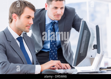 Businessmen using computer at office desk Stock Photo