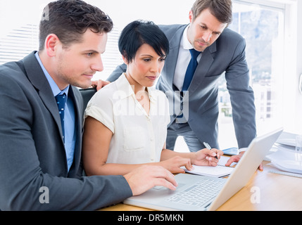 Colleagues using laptop at office desk Stock Photo