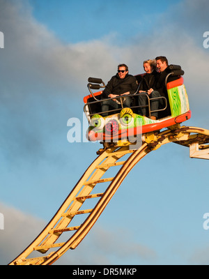 Three people on the Crazy Mouse roller coaster ride on Brighton Pier, UK Stock Photo