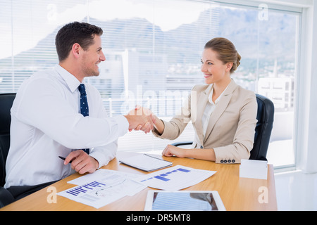Smartly dressed colleagues shaking hands in a business meeting Stock Photo