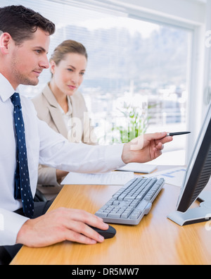 Smartly dressed colleagues using computer Stock Photo