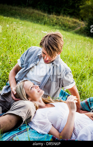 Happy young couple relaxes in the meadow, foothills of the Alps, Bavaria, Germany Stock Photo