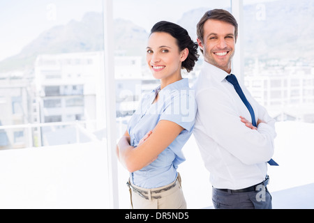 Smiling young business couple with arms crossed Stock Photo