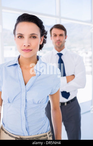 Serious businesswoman with male colleague in background Stock Photo