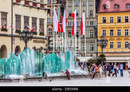 The modern fountain against a backdrop of reconstructed houses in Wroclaw's old town Market Square or Rynek. Stock Photo