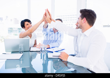 Executives giving high five in a business meeting Stock Photo