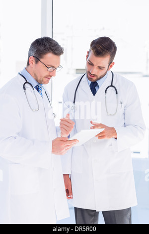 Concentrated two male doctors using digital tablet Stock Photo