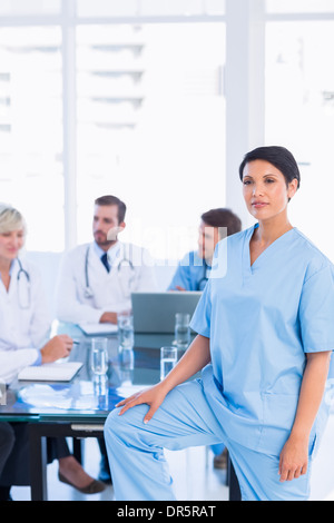 Serious female surgeon with colleagues in meeting Stock Photo