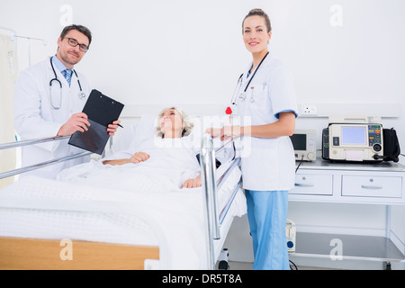 Doctors visiting a female patient in hospital Stock Photo