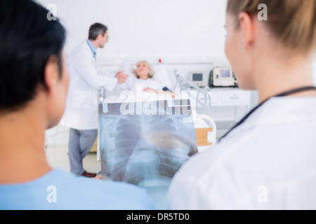 Rear view of doctors with blurred patient in hospital Stock Photo
