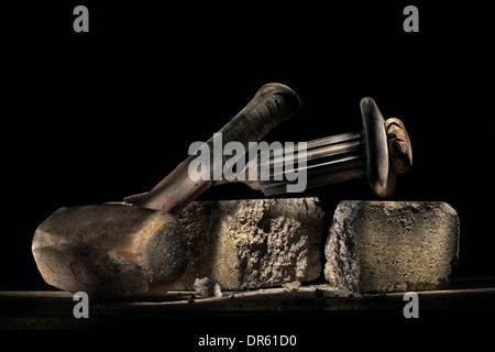 Builder's lump hammer and bolster resting on a concrete brick. Stock Photo