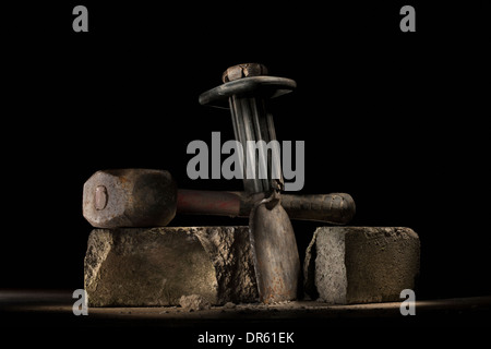 Builder's lump hammer and bolster resting on a concrete brick. Stock Photo