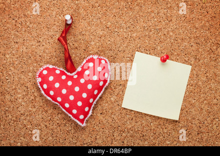 Blank note with toy heart on wooden cork board Stock Photo