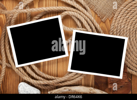 Travel photo frames on wooden texture with burlap and rope around Stock Photo