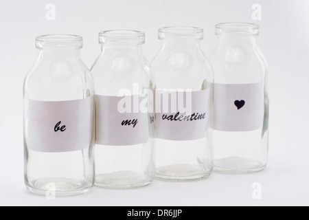 Four Glass Bottles With Message 'Be My Valentine' Isolated On A White Studio Background Stock Photo