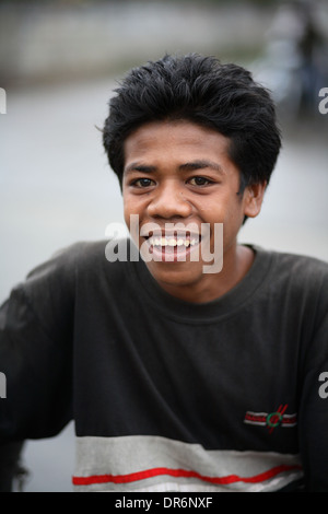 Shallow focus portrait of smiling Indonesian teenage boy looking at ...