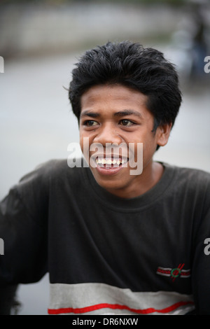 Shallow focus portrait of smiling Indonesian teenage boy looking left .  Kupang, West Timor, Indonesia. Nov 2005 Stock Photo