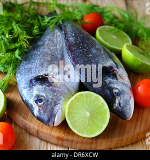 two uncooked fish dorado on board, food closeup Stock Photo