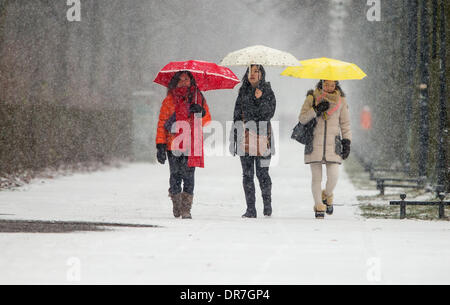 Berlin, Germany. 21st Jan, 2014. Three Korean tourists walk with umbrellas as it snows in Berlin, Germany, 21 January 2014. Photo: HANNIBAL/dpa/Alamy Live News Stock Photo