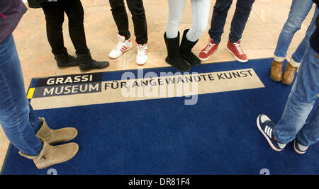 Visitors stand at a carpet with the writing 'Grassi Museum für angewandte Kunst' (lit: Grassi Museum for applied art) in Leipzig, Germany, 21 January 2014. Today the museum took stock of the past year 2013 and gave a preview of the highlights of 2014. Photo: Peter Endig/dpa Stock Photo