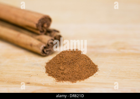 Cinnamon sticks and ground cinnamon on a wooden board. Stock Photo