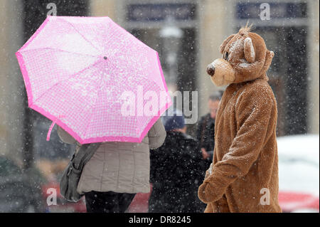 Berlin, Germany. 21st Jan, 2014. An actor dressed as Berlin Bear stands in front of the Brandenburg Gate during snowfall in Berlin, Germany, 21 January 2014. Photo: Maurizio Gambarini/dpa/Alamy Live News Stock Photo