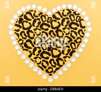 Black and gold animal print heart surrounded by white rhinestones on gold background Stock Photo