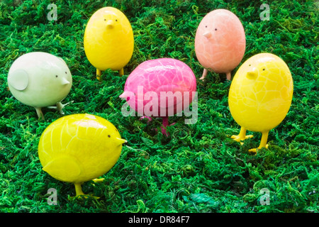 Group of assorted colorful egg chickens on green moss Stock Photo