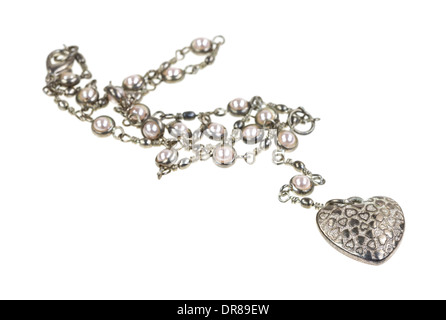A heart shaped pendant on a silver chain with fake pearls on a white background. Stock Photo