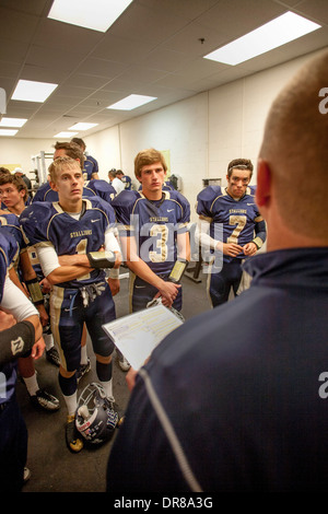 High school football players listen to their coach during half time of a night game in San Juan Capistrano, CA. Stock Photo