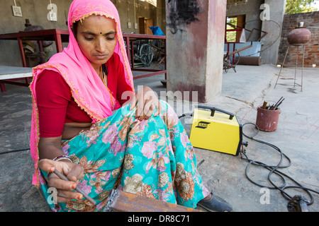 Women testing the welding joints during the construction of solar cookers at the Barefoot College in Tilonia, Rajasthan, India. Stock Photo