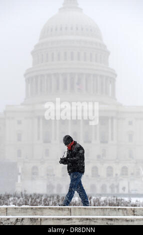 Washington DC, USA. 21st Jan, 2014. A man walks past the Capitol in Washington DC, the United States, Jan. 21, 2014. Thousands of flights were canceled, students got an extra day off from school or were being sent home early, and the federal government closed its offices in the Washington area Tuesday as a winter storm bore down on the East Coast. Credit:  Yin Bogu/Xinhua/Alamy Live News Stock Photo