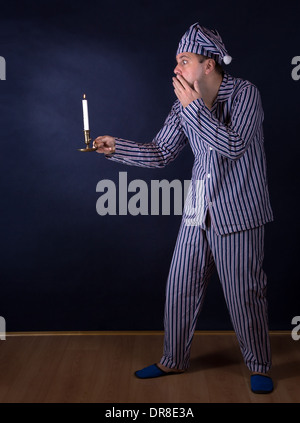 frightened man with candle in pajamas Stock Photo - Alamy