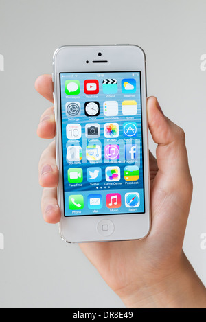 iOS 7 home screen of white Apple iPhone 5 Stock Photo