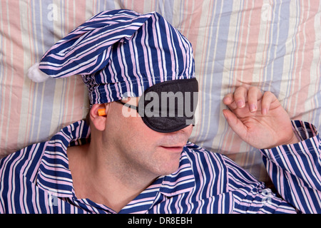 man sleeping with a mask on eyes Stock Photo