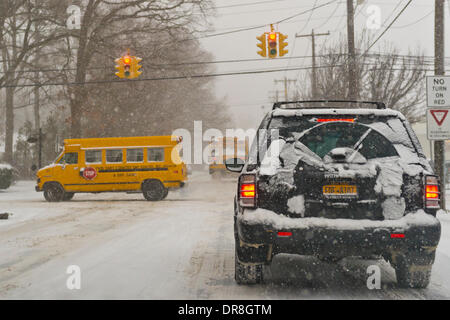 Merrick, New York, U.S. January 21, 2014. School buses are seen going slowly on snowy streets when Long Island schools close early, with up to 10 inches of snow expected during snow storm. Stock Photo