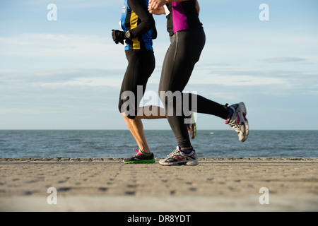 Two women running jogging competing in the Aberystwyth 10k race, December 2013 Stock Photo