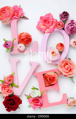 a letter saying love with roses around Stock Photo