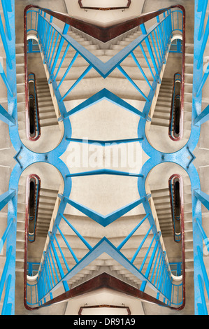 Vertigo anxiety and fear of heights a 6 floor stairwell trapped with steel blue handrail and dark and dingy flight of stair Stock Photo