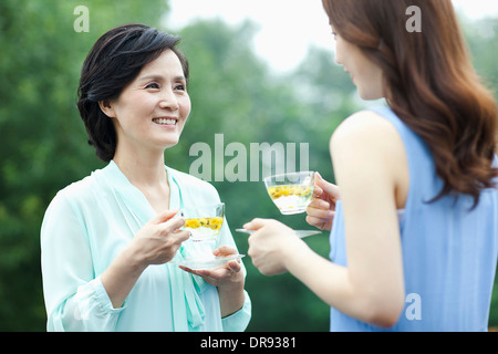 mother and grown up daughter having cup of tea Stock Photo