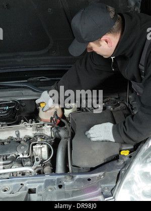 Auto mechanic unscrewing coolant tank Stock Photo