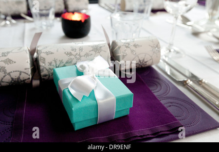 Christmas table present  at the Christmas table dinner place setting, with christmas cracker, UK Stock Photo