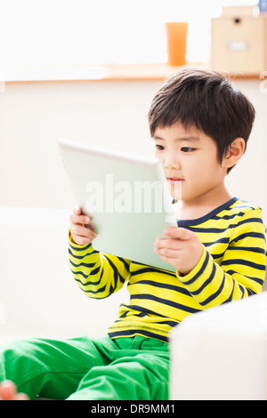 a boy playing with a tablet Stock Photo