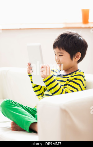 a boy playing with a tablet Stock Photo