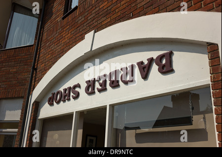 Upside down shop sign outside a Barbers Shop in UK Stock Photo