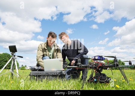 Technicians Working On Laptop By UAV in Park Stock Photo