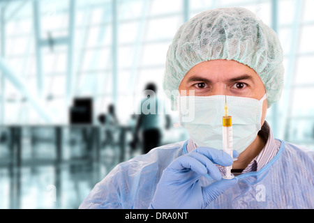 young male doctor with mask holding syringe Stock Photo
