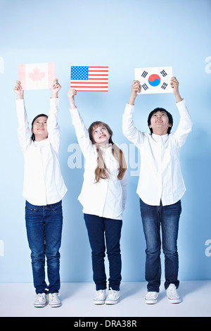 three kids holding different flags Stock Photo