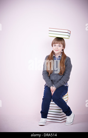 Girl sitting with a pile of books Stock Photo - Alamy